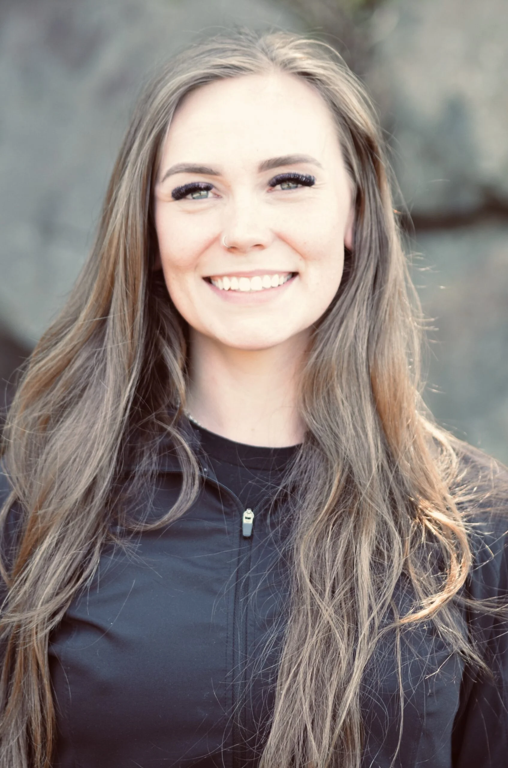Female dental assistant in Burien, WA standing outside dental office